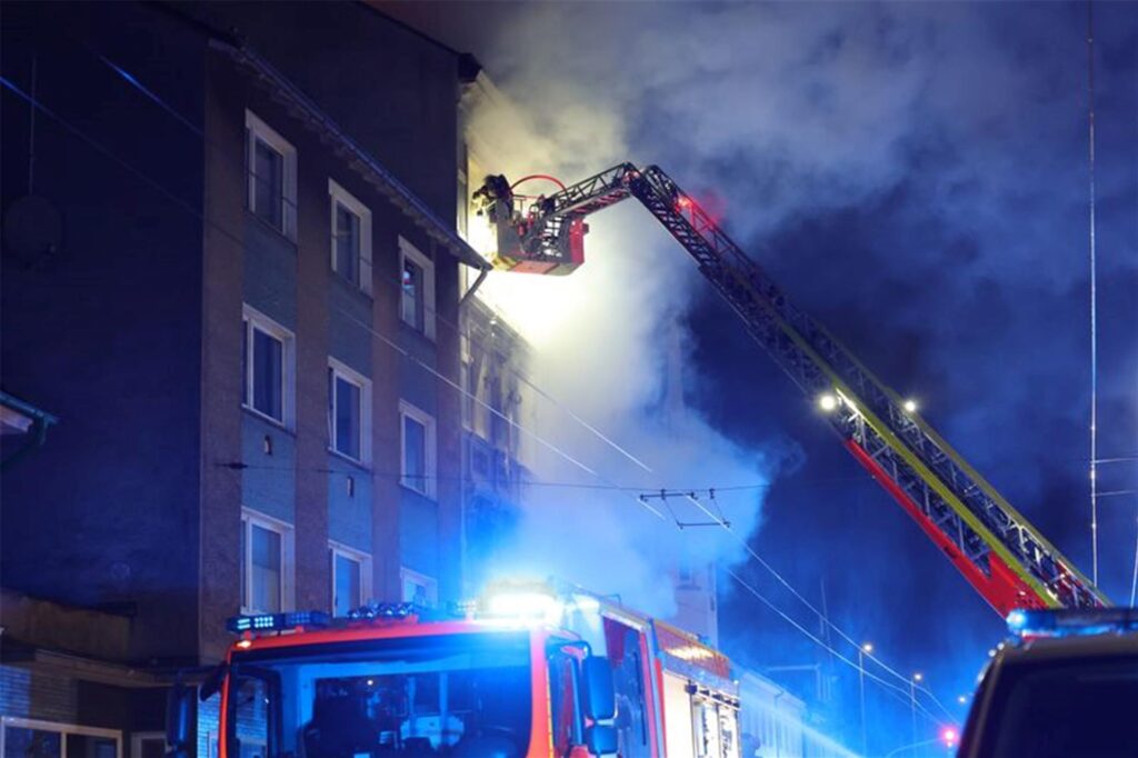 Ein Feuerwehrmann klettert an einem Haus in Solingen, in dem es gebrannt hat, auf einer Leiter. 