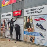 Mitarbeiter einer Werbetechnik-Firma folieren ein Ladenlokal auf dem Westenhellweg in Dortmund.