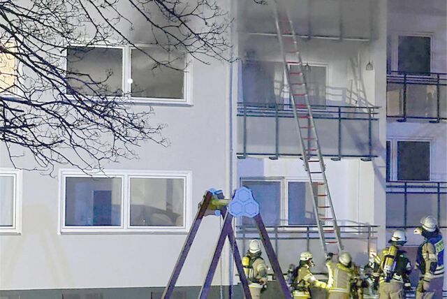 Einsatzkräfte dringen am 22. März über Leitern in ein verrauchtes Gebäude in Menden vor.