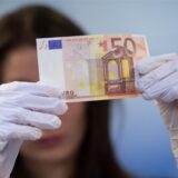 Eine Bank-Mitarbeiterin prüft einen 50-Euro-Schein