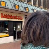 Eine Frau steht mit dem Rücken zur Kamera vor der Schickentanz-Filiale in der Castroper Altstadt.