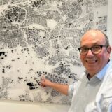 Verkehrsexperte Michael Frehn zeigt auf eine Karte an der Wand.
