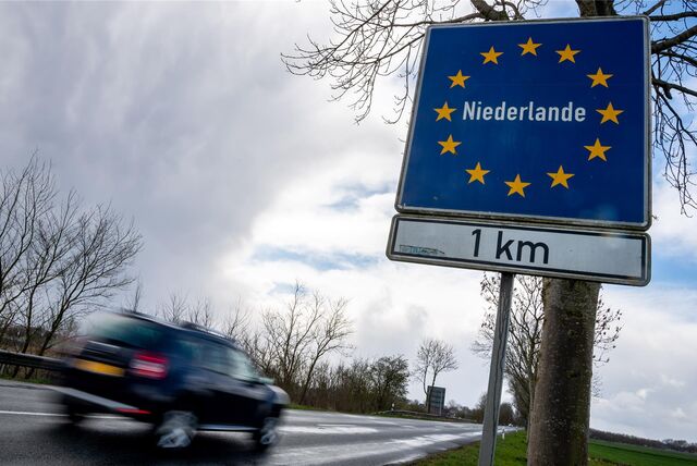 Ein Auto fährt an einem Schild vorbei, das auf die Grenze zu den Niederlanden hinweist.