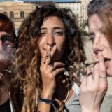 Drei Frauen rauchen auf einer Demo einen Joint.