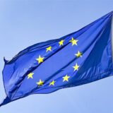 Eine Europaflagge weht vor blauem Himmel.