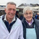 Klaus Eickenscheidt (links) und seine Frau Elisabeth stehen auf dem Wochenmarkt in Waltrop vor ihrem Eier-, Geflügel- und Wildstand. Im Hintergrund sind wartende Kundinnen zu sehen.