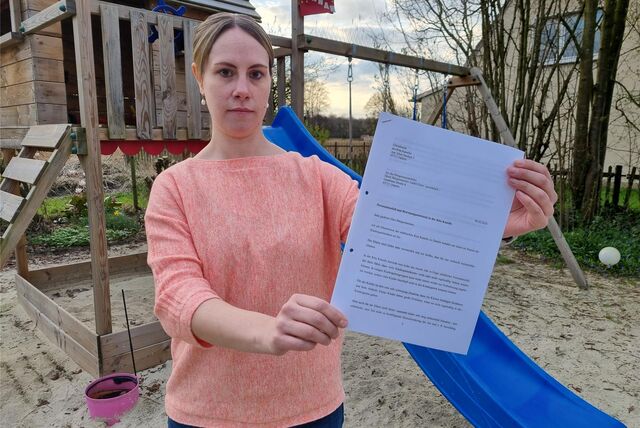 Eine Frau hält einen Brief in der Hand.