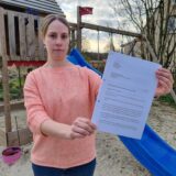 Eine Frau hält einen Brief in der Hand.
