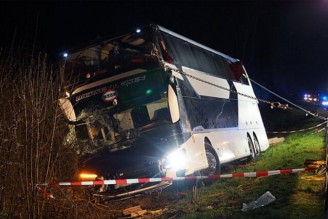 Ein Bus ist von der Autobahn A44 abgekommen. Mit Seilen und Gurten wurde er wieder aufgerichtet. Im Vordergrund ist Flatterband zu sehen.