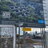 Die ersten fast fertigen Häuser im Baugebiet Mariengärten sind nur durch einen Zaun zu sehen. Die Baustelle ruht wegen der Insolvenz der Tecklenburg GmbH. Das Bauschild zeigt, was hier geplant ist.
