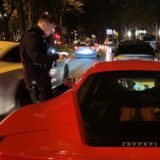 Polizisten kontrollieren einen roten Ferrari auf dem Dortmunder Wall.