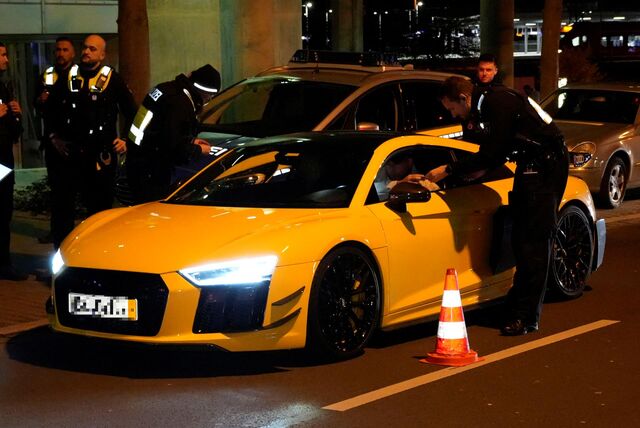 Polizisten kontrollieren einen Audi R8 auf dem Dortmunder Wall.