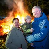 Eine Familie mit Kind steht vor einem Osterfeuer in Recklinghausen.