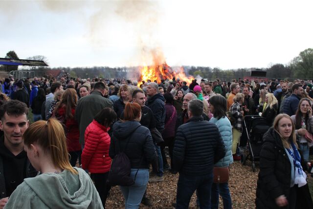 Zahlreiche Besucher stehen um das Osterfeuer bei Bauer Südfeld in Herten-Scherlebeck.
