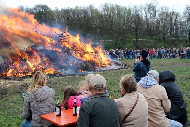 Viele Hertener sitzen und stehen um das Osterfeuer bei Bauer Godde in Herten.
