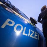 Eine Polizistin steht an einem Polizeiwagen