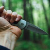 Eine Hand hält ein aufgeklapptes Messer.
