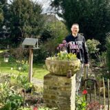 André Winkler aus Recklinghausen steht am Eingang seines Gartens hinter einem Pflanzkübel.