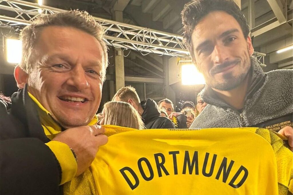 Zwei Männer halten ein Dortmund-Trikot.