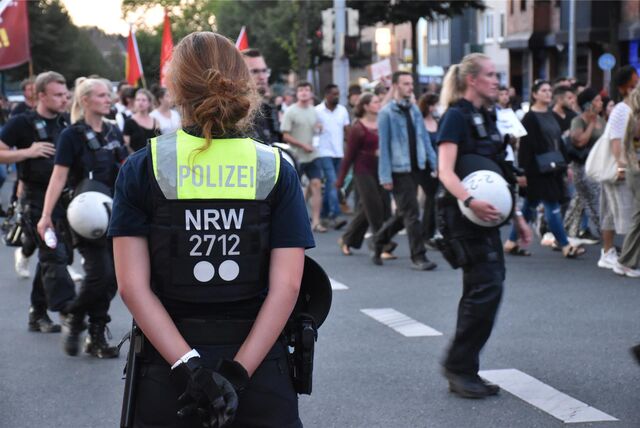 Polizeibeamte und Polizeibeamtinnen sichern einen Demonstrationszug in Dortmund.