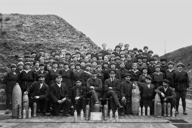 Historisches Bild der Wasag-Belegschaft von 1918 – Männer und Frauen in dunkler Kleidung mit Hüten oder Kopftüchern