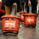 Menschen mit Einkaufskörben kaufen bei TK Maxx ein.