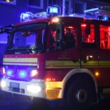 Ein Feuerwehrwagen steht mit Blaulicht in einer Straße.