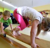 Kinder hüpfen über eine Bank.