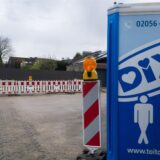 Ein Dixie-Klo, im Hintergrund eine Baustelle.