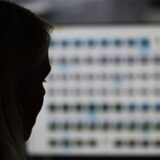 Eine Frau sitzt vor einem Computerbildschirm.