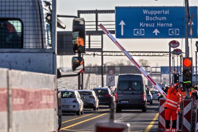 Bauarbeiter sperren die A43 mit einer Ampelschranke ab. (Symbolbild)