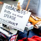 Ein Schild, auf denen ein Obdachloser um Spenden bittet.