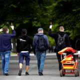 Männer gehen am Vatertag mit einem Bollerwagen einen Weg entlang.