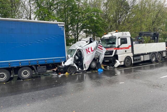 Demolierter Transporter, eingeklemmt zwischen zwei Lkw.