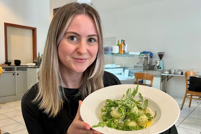 RN-Volontärin Julia Segantini sitzt im Restaurant „Pasta Buonissima“ in Dortmund und hält einen Teller mit Gnocchi in den Händen.