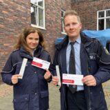 Die Polizisten Nadine H. und David R. stehen mit Typisierungs-Material vorm Polizeipräsidium Recklinghausen.