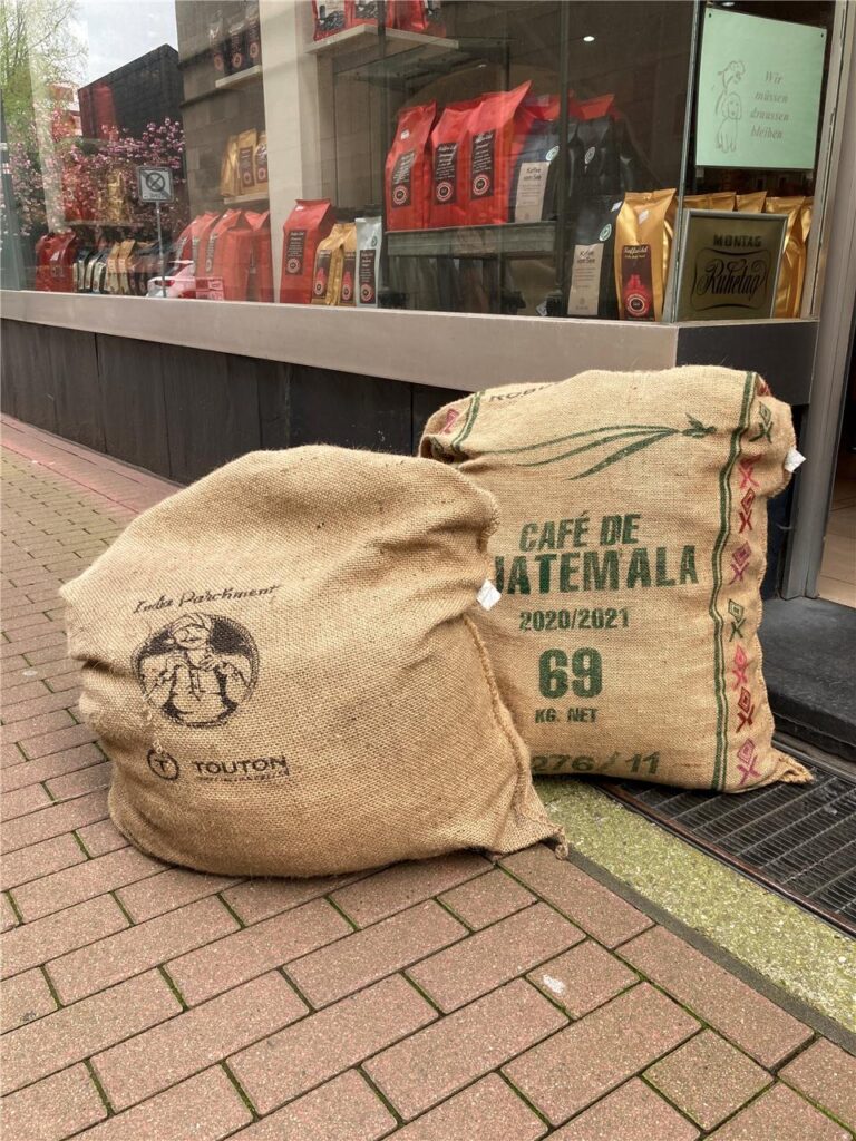 Zwei Kaffeesäcke aus Jute liegen vor einer Rösterei in Recklinghausen.