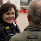 Eine Polizistin und ein Passant im Gespräch. Vom Mann ist nur der Hinterkopf zu sehen.
