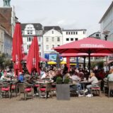 Viele Menschen sitzen auf Stühlen der Außengastronomie auf dem Altstadtmarkt in Recklinghausen.