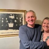 Ehepaar Willi Bergjürgen und Steffi Assmann vor einem alten Familienbild an der Wand