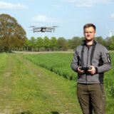 Zwei Männer stehen auf einem Feld mit einer Flugdrohne.