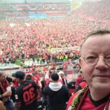 Platzsturm in der Bayarena und FLVW-Direktor Wilfried Busch als Fan auf der Nordtribüne. Der Meisterschal um seinen Hals hat eine besondere Geschichte.