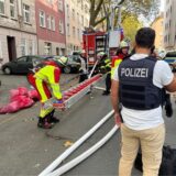 Polizisten und Feuerwehrleute bei einem Brandeinsatz auf der Schillerstraße in Dortmund.