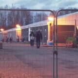 Mitarbeiter eines Sicherheitsdienstes und Bewohner der Notunterkunft in der Abenddämmerung.