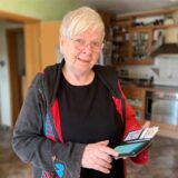Renate Nöbe steht in ihrer Küche und hält ihr Smartphone in den Händen.