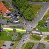 Blick von oben auf das Bahnhofsterrain in Sythen mit Zug auf den Gleisen