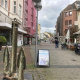 Ansicht der Fußgängerzone Hohe Straße in Datteln. Im Vordergrund links ein Anker, in der Bildmitte steht eine Laterne, daneben ein Werbeschild. Im Hintergrund sind Gebäude und Passanten zu erkennen.