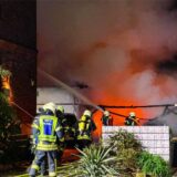 Die Hertener Feuerwehr bekämpft in einer Hof-Einfahrt deutlich erkennbare Flammen.