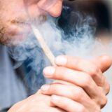 Ein Mann raucht bei der Auftaktkundgebung einer Demonstrationen für eine zügige Legalisierung von Cannabis, dem «Global Marijuana March 2022», am Brandenburger Tor einen Joint mit Medizinalcannabis.