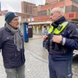 Polizeihauptkommissar Andreas Lücking (rechts) steht auf dem Hertener Marktplatz und unterhält sich mit einen Mann.